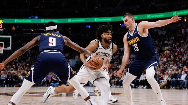 Brooklyn Nets forward Trendon Watford (9) drives to the net against Denver Nuggets forward Justin Holiday (9) and center Nikola Jokic (15)